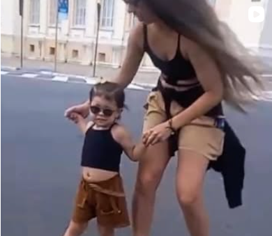 Mãe de mãos dadas com a filha em cima do longboard